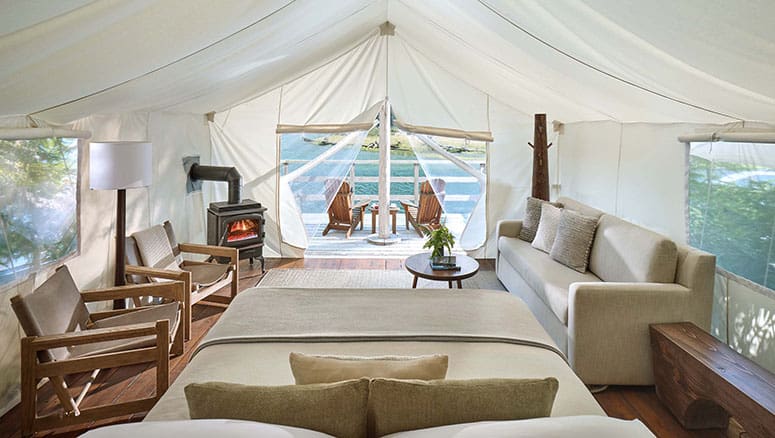 Luxury canvas tents at Clayoquot Wilderness Lodge set beside forested mountains and misty inlets on Vancouver Island.